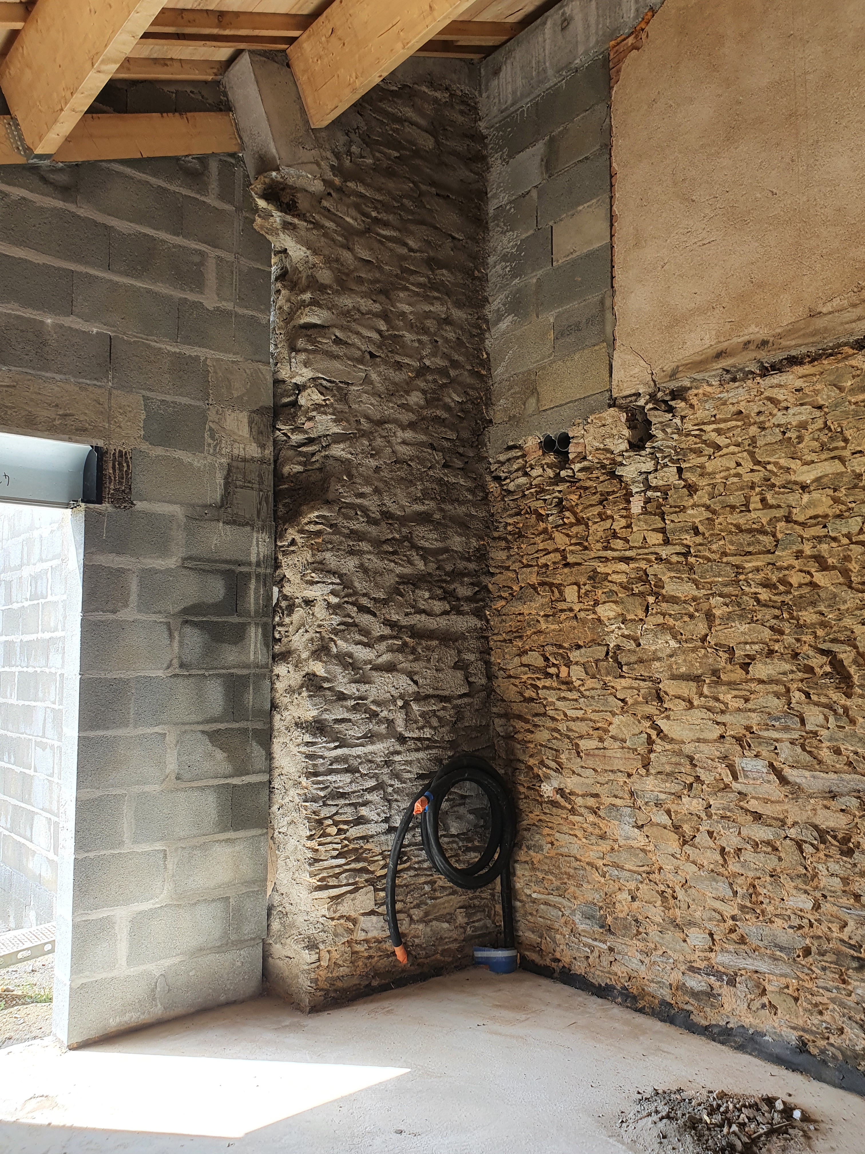 Chambre avec niche en pierre au-dessus du lit, mur bleu marine et décoration ambre — Projet Tremblay, architecture d'intérieur à Rennes