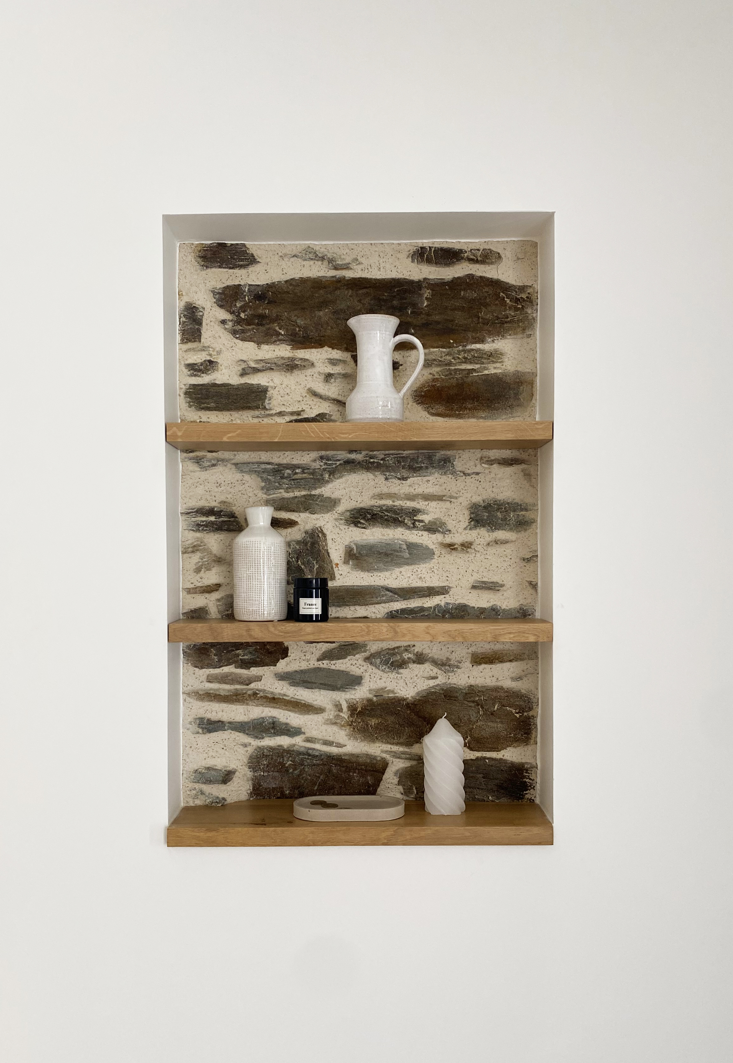 Niche en pierre naturelle avec étagères bois et objets déco blancs — Projet Tremblay, rénovation grange familiale