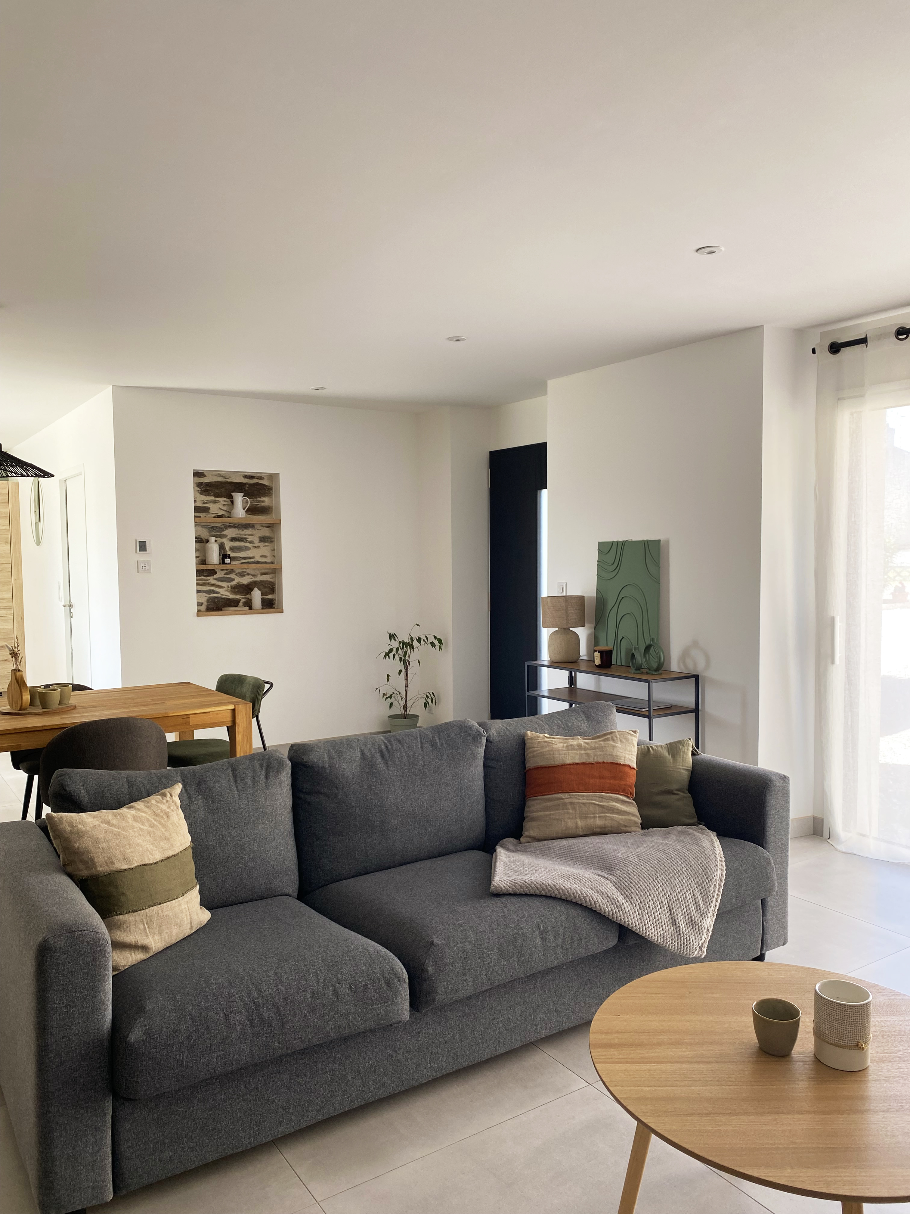 Salon avec canapé gris, éléments déco kaki et ambre, table basse bois — Projet Tremblay, architecture d’intérieur Rennes