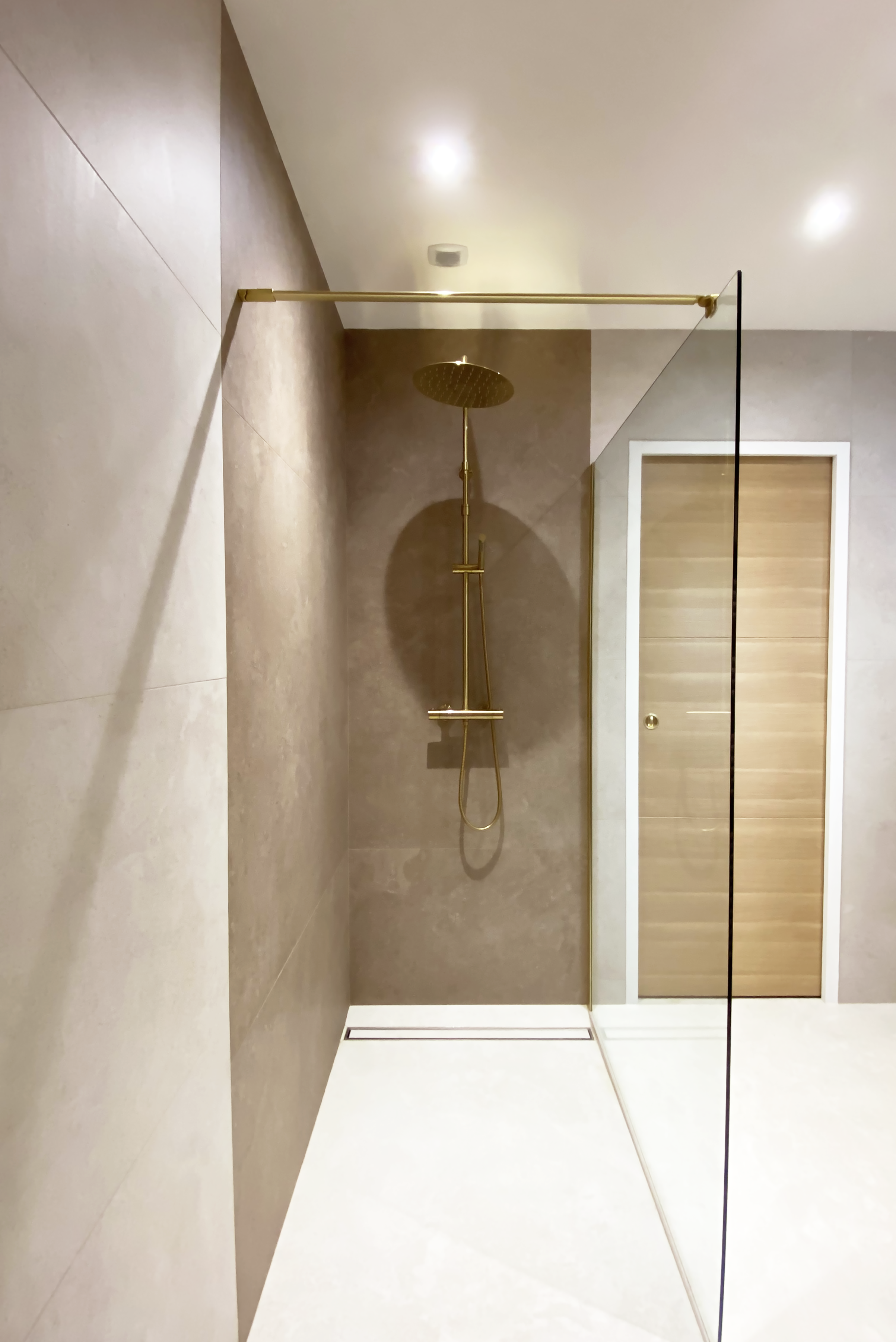 Douche à l'italienne, carrelage taupe, colonne dorée, paroi vitrée dorée — Projet N&C, salle de bain rénovée