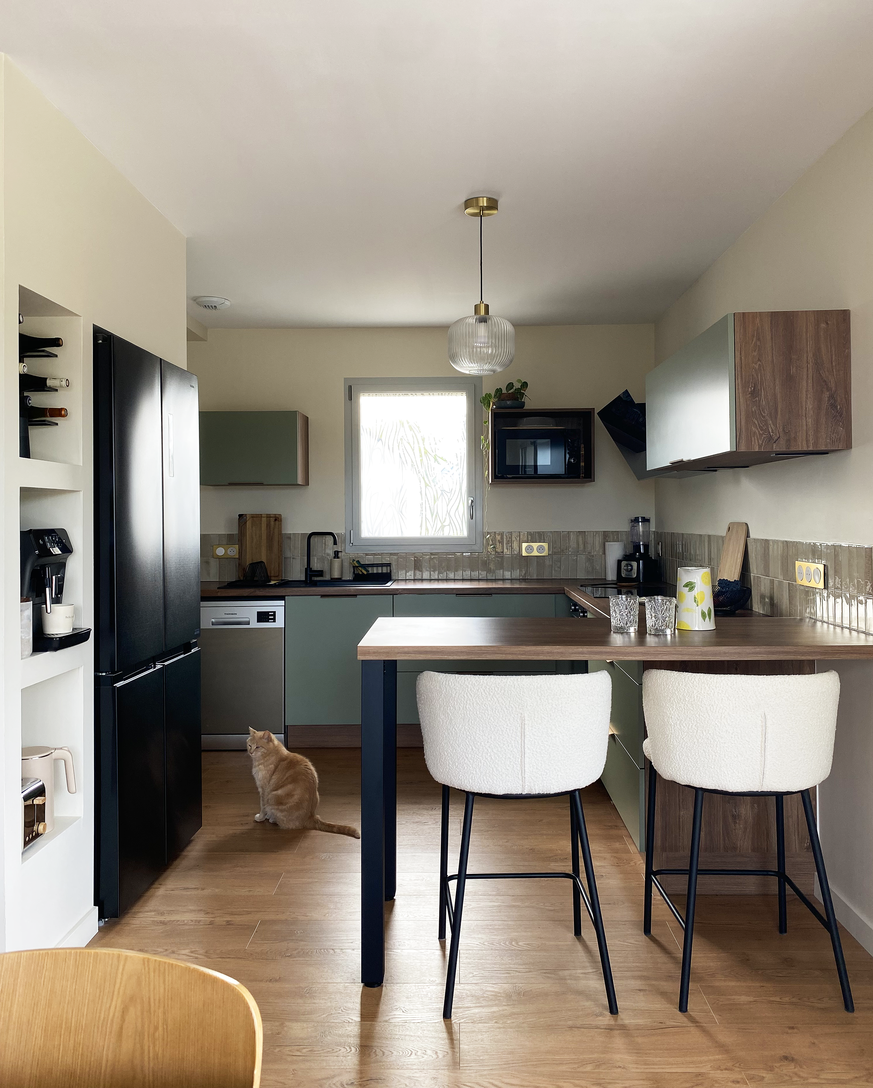 Cuisine vert saige et bois, implantation en U, ouverte — Projet La Hutte